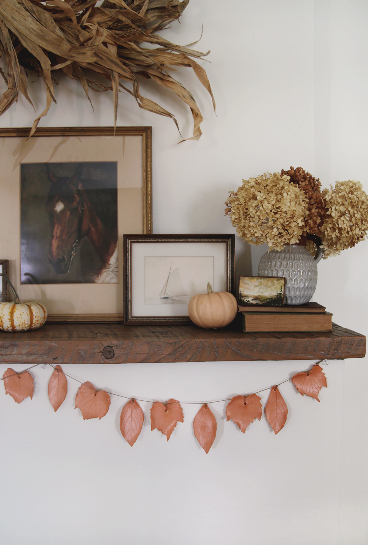 fall clay leaf garland hanging on mantel with fall decor on mantel